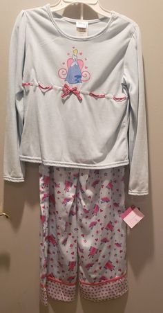 DISNEY CINDERELLA SLEEPWEAR PAJAMAS SET!THIS IS NEW WITH TAGS. A SUPER CUTE SET OF PAJAMAS THAT HAVE A PRETTY BLUE TOP WITH RIBBON ACCENT AND A GLITTERY PRINT OF CINDERELLA ON FRONT. THE LOUNGE PANTS ARE A SILKY SOFT MATERIAL AND HAVE CASTLES AND CINDERELLA GLASS SLIPPER PRINT ALL OVER. THIS IS A GIRLS SIZE 10-12. GREAT FOR ANY FAN! THINK GREAT GIFT! SHIPPING IS A FLAT RATE OF $8.95. Sorry, I do not accept refunds and request you do not purchase item from me if you intend to return it. I provide Cinderella Glass Slipper, Cute Pajama Set, Pajamas Long Sleeve, Silky Pants, Girls Disney, Cute Pajama Sets, Disney Cinderella, Baby Closet, Girls Sleepwear