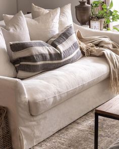 a white couch with pillows and blankets on it