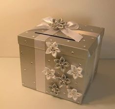 a silver box with white flowers on it