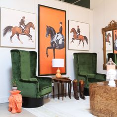 a living room filled with green chairs and paintings on the wall above them is a coffee table