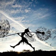 a woman is flying through the air with two dandelions in her hand,