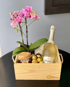 a wooden box filled with wine, chocolates and flowers