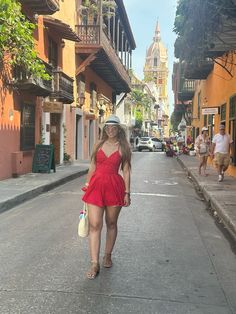 a woman in a red dress walking down the street