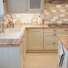 a kitchen with white cabinets and wooden counter tops