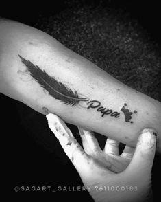 a black and white photo of a person's arm with a tattoo on it