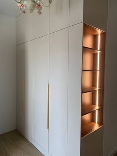 an empty room with white cupboards and lights