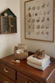 a wooden dresser sitting next to a wall with pictures on the wall and shoes on top of it