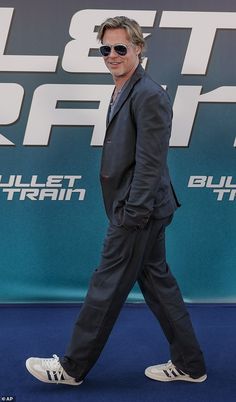 a man walking across a blue carpeted floor