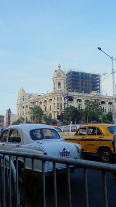 many cars are parked on the street in front of some buildings and traffic lights,