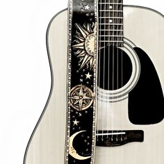 an acoustic guitar with the sun and moon painted on it's back side, against a white background