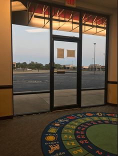 the entrance to an empty parking lot is seen through large glass doors with numbers on them