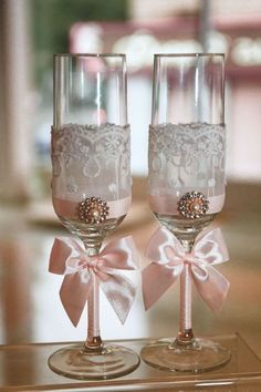 two wine glasses with bows and lace on them