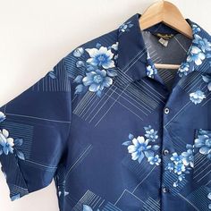 Funky vintage summer shirt in navy blue floral. It has short sleeves, a single chest pocket and an open v-neck collar.Made in California by Mr. Jan.100% polyester, sateen weave (smooth and silky in the outside).XL size, measurements when laid flat are:Pit to pit: 64cmWaist: 58cmLength: 72cmExcellent condition. Summer V-neck Hawaiian Shirt, Summer Collared Hawaiian Shirt With Pockets, Collared Hawaiian Shirt With Pockets For Summer, Summer V-neck Printed Hawaiian Shirt, Retro V-neck Summer Shirt, Collared Hawaiian Shirt With Pockets For Beach, Summer Vacation Short Sleeve Shirt With Johnny Collar, Johnny Collar Short Sleeve Shirt For Summer Vacation, Vintage Print Relaxed Fit Summer Shirt