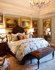 a large bed sitting in a bedroom under a chandelier