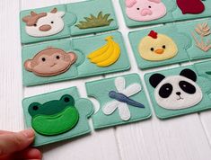 a person is holding up some felt animals and plants on the same placemats