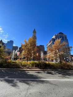 a city street with tall buildings and trees in the foreground