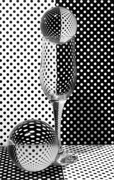 two wine glasses sitting next to each other on top of a black and white floor