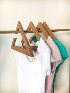 clothes hanging on wooden hangers in front of a white wall and brown door frame