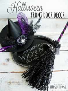 a black witches hat with purple feathers on it and the words, halloween front door decor