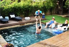 some kids are playing in the pool and having fun with their dad's water toys