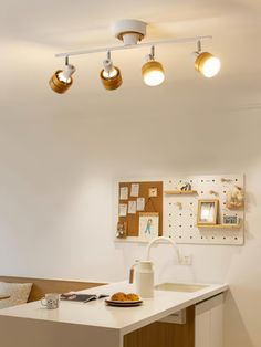 a kitchen with three lights hanging from the ceiling and a counter in front of it