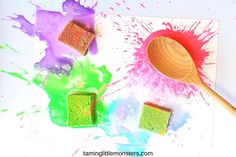 colorful powder and wooden spoon on white surface