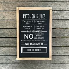 a black and white kitchen rules sign hanging on a wooden wall