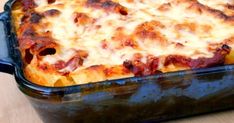 a casserole dish with cheese and meat in it on a wooden table top