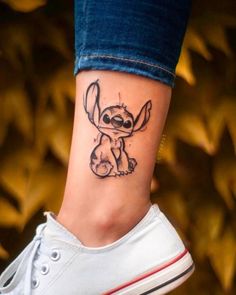 a small tattoo on the ankle of a woman's foot, featuring a cartoon character