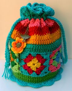 a colorful crocheted bag sitting on top of a white table next to a wall