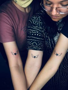 two people with matching tattoos on their arms