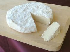 a piece of cheese is sitting on a cutting board