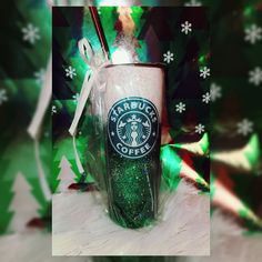 the starbucks cup is decorated with green glitter