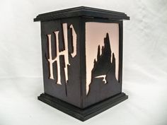 a black lantern with the word harry on it and a hogwarts castle silhouette