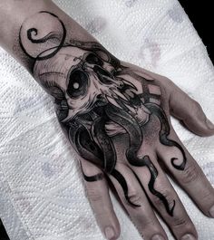 a hand with a skull on it and an octopus in the middle is tattooed to look like