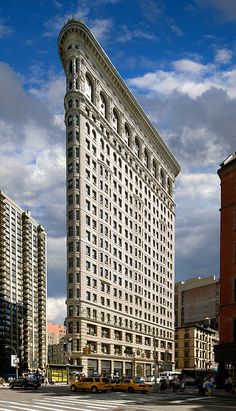 a very tall building sitting in the middle of a street next to other large buildings