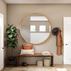 a large round mirror hanging on the wall above a wooden bench with pillows and hats