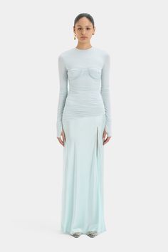 The Alessia Draped Gown is a long sleeved, full length dress crafted from fluid viscose jersey layered with a lustrous satin sheen in a soft ice blue colourway. Offering a fitted upperhalf with an exposed bra detail and gathering before draping into a relaxed narrow skirt with a split detail. Fitted Pre-draped Long Sleeve Maxi Dress, Gala Long Sleeve Maxi Dress With Ruched Bodice, Long Sleeve Maxi Dress With Ruched Bodice, Fitted Long Sleeve Pre-draped Maxi Dress, Draped Gown, Drape Gowns, Drape Panel, Full Length Dress, Dress Crafts