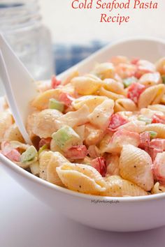 a white bowl filled with pasta salad on top of a table