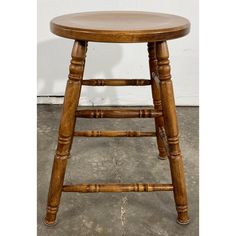 a wooden stool sitting on top of a cement floor