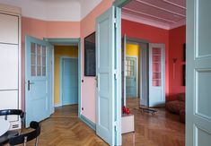 an empty room with blue doors and pink walls