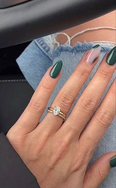 a woman's hand with green and white nail polish on her nails, wearing a ring