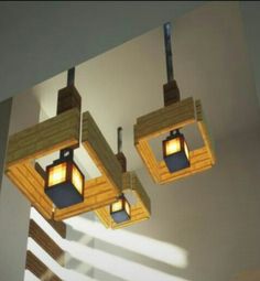 three wooden lights hanging from the ceiling in a room with white walls and shadows on the wall