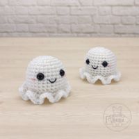 two small crocheted octopus figurines sitting on top of a wooden table