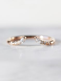 a gold ring with two small diamonds on it