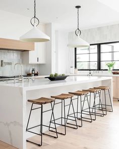 a kitchen island with four stools next to it