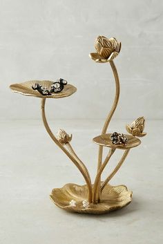 two gold flower shaped candlesticks sitting on top of each other