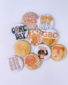 a pile of buttons with different designs on them, all in orange and white colors