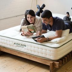 a man and woman laying on top of a bed with an inflatable mattress