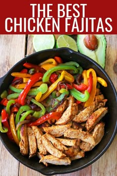 a pan filled with chicken and peppers on top of a wooden table